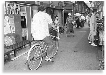 "Untitled". Bicyclist at the entrance of Sensoji Temple, Asakusa, Tokyo, 2002.