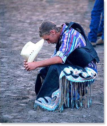 During a prayer before the M Bar M Ranch rodeo, Santa Fe, Texas. Photo by Nic Paget-Clarke.