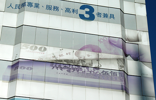 Images of two currency notes, of Taiwan and China, on a skyscraper in Taipei, Taiwan, 2016. Photo by Nic Paget-Clarke.